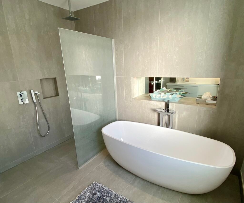 Modern bathroom with freestanding bath and walk-in shower, designed and built by Torwood Interiors in Purley, London.