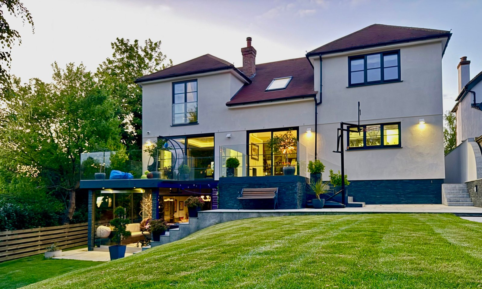 Modern double-storey house extension in Purley with glass balustrade terrace and landscaped garden, built by Torwood
