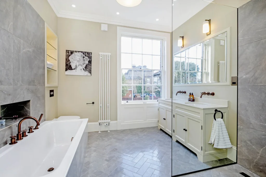 Bright Georgian bathroom with marble double vanity, glass shower and sash window in Richmond TW9