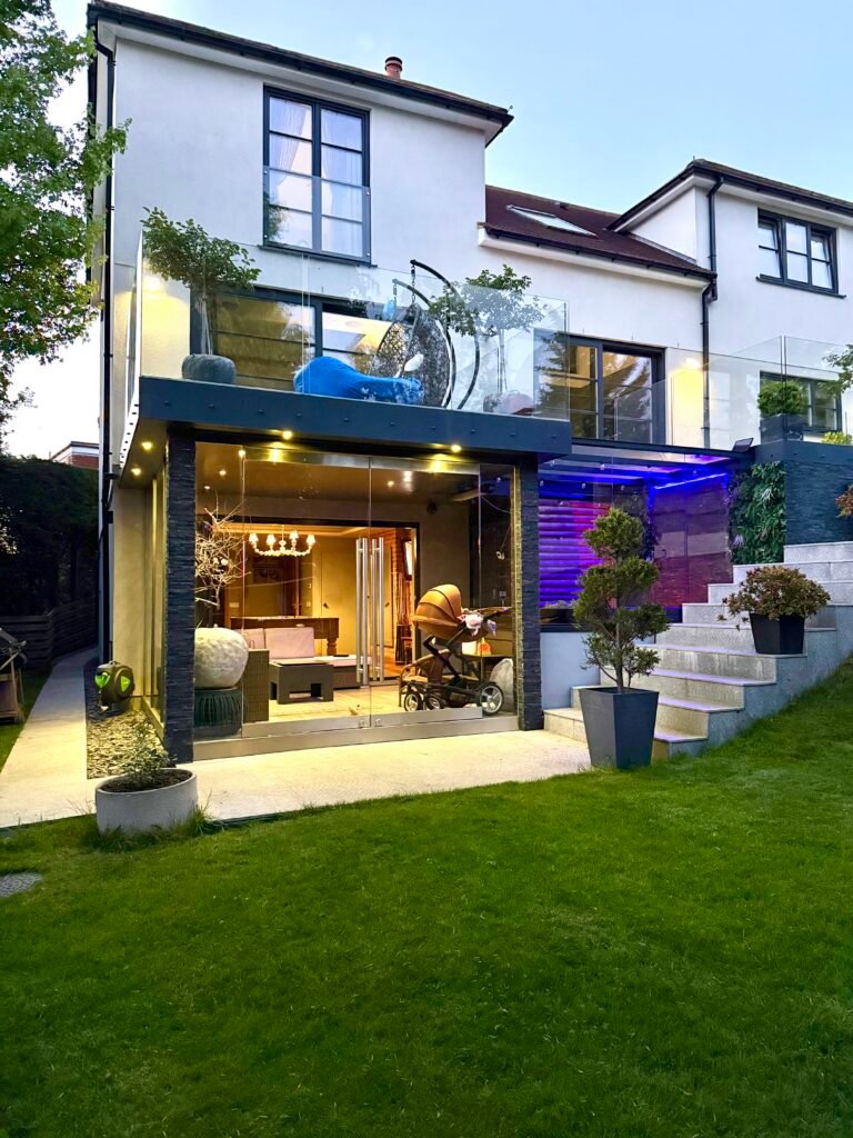 Modern rear house extension with glass balcony and garden steps, designed and built by Torwood Interiors in Purley, London.