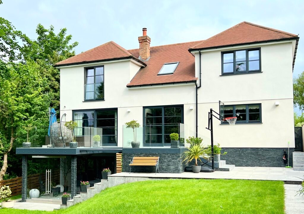 Modern two-storey house renovation and extension in Purley, glass balcony and cream render exterior, completed by Torwood