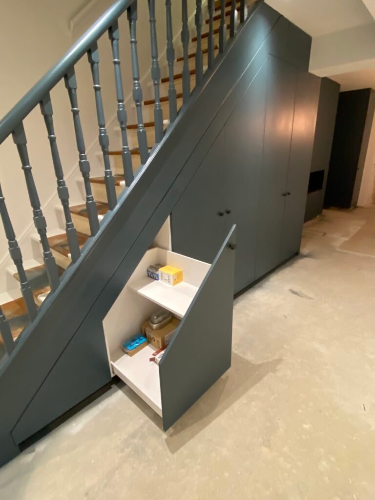 Bespoke understair pull-out storage unit with painted finish, designed and built by Torwood Interiors in Richmond.