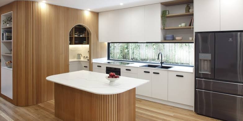 Bright kitchen with white units, timber panelling and a feature island